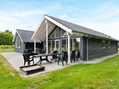 a cabin with a table and chairs on a deck at 16 person holiday home in Glesborg in Fjellerup Strand