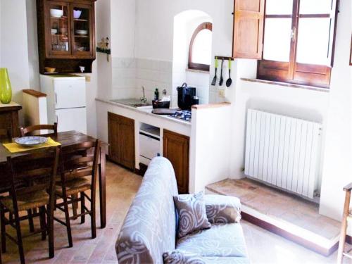 Una cocina con un sofá y una mesa en una habitación. en Cosy apartment in Mantignana with private terrace, en Mantignana