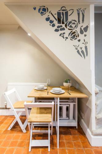 a dining room with a table under the stairs at Terraced Taylor in Southborough