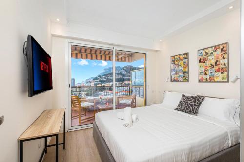 een slaapkamer met een groot bed en een balkon bij Monaco border - Balcon vue mer - DD in Beausoleil