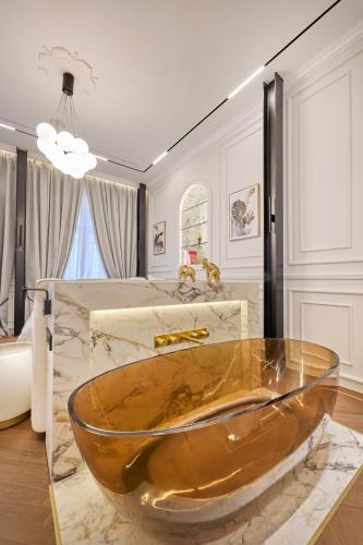 a gold tub in a bathroom with a sink at Ermou 99 Intelligent Private Suites in Athens
