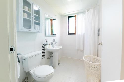 a white bathroom with a toilet and a sink at Tov Stay Atti in Pyeongtaek