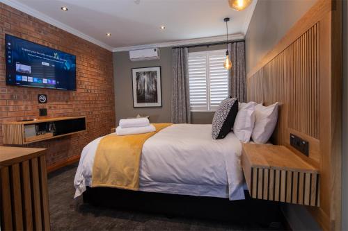 a bedroom with a large bed and a tv at Haisley Hotel in Hilton
