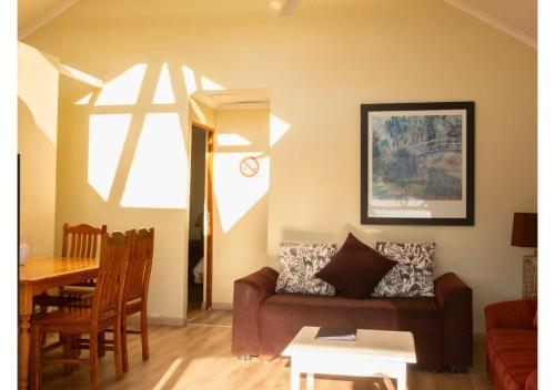 a living room with a couch and a table at Imbabali Retreat & Venue in Magaliesburg