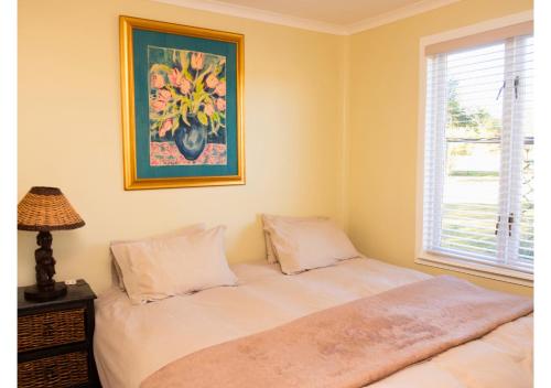 a bedroom with a bed with a picture on the wall at Imbabali Retreat & Venue in Magaliesburg