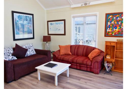 a living room with two couches and a table at Imbabali Retreat & Venue in Magaliesburg