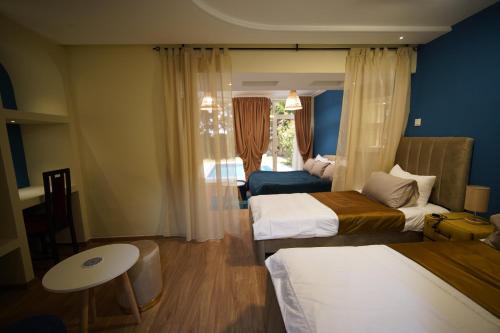 a hotel room with two beds and a table and a window at MDE Loisir Tanjis m in Tangier