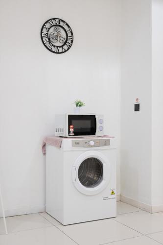 a washing machine with a microwave on top of it at MCity Jalan Ampang KLCC in Kuala Lumpur