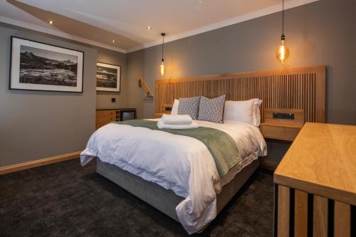 a bedroom with a large bed with a wooden headboard at Haisley Hotel in Hilton