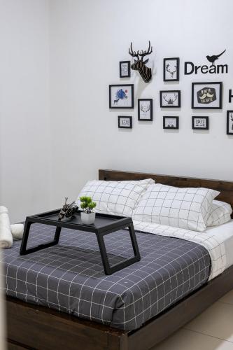 a bed with a table on it with pictures on the wall at MCity Jalan Ampang KLCC in Kuala Lumpur
