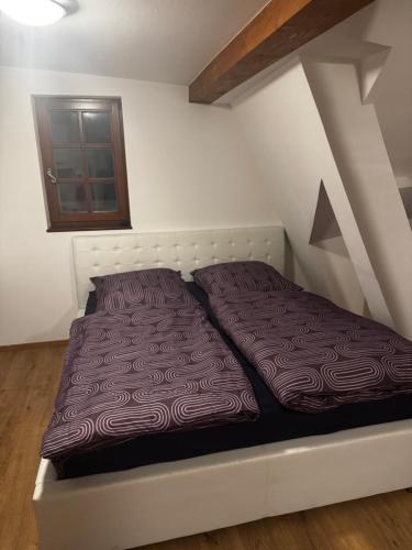 a bed in a small room with a window at Cozy one-room apartment in Nürnberg