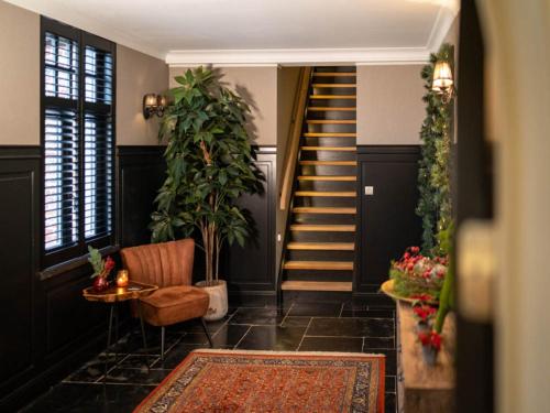 einen Flur mit einer Treppe, einem Stuhl und einem Teppich in der Unterkunft Beautiful holiday home in Vlaanderen with shared pool in Heissehuizen