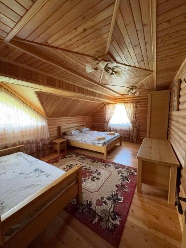 an attic room with two beds and a table at Смерековий двір in Slavske