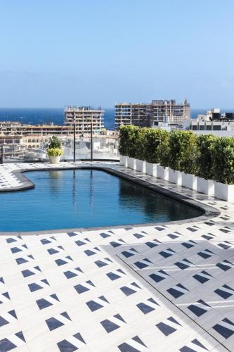 a swimming pool on the roof of a building at Mercury Suite Bright w Pool access by Arco Collection in St. Julianʼs