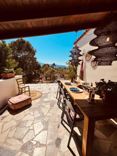 a patio with a wooden table and chairs at Villa Feronia Samos in Mesókampos