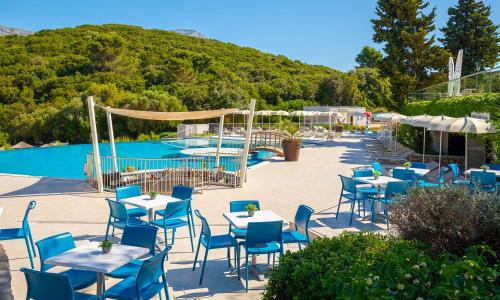 a group of tables and chairs next to a pool at Aminess Vival Port9 Residence in Korčula