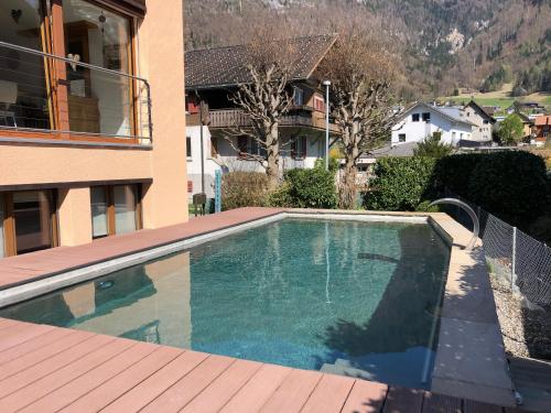a swimming pool in the backyard of a house at Zimmer mit eigenem Badezimmer in Näfels
