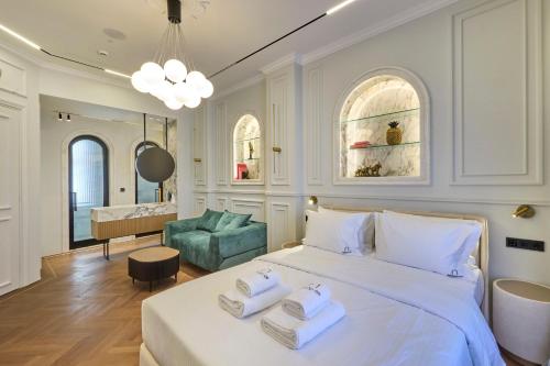 a bedroom with a large white bed with towels on it at Ermou 99 Intelligent Private Suites in Athens