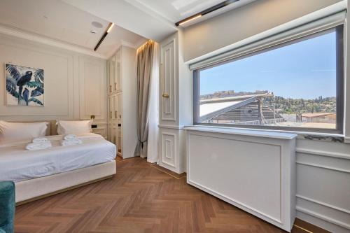 a bedroom with a bed and a large window at Ermou 99 Intelligent Private Suites in Athens