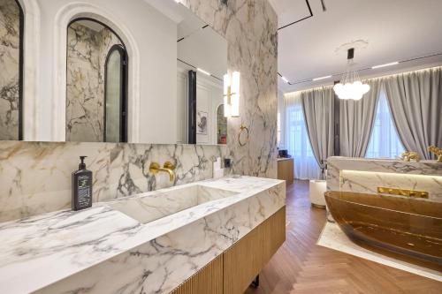 a bathroom with a large tub and a large mirror at Ermou 99 Intelligent Private Suites in Athens