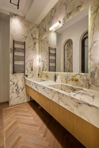 a bathroom with two sinks and a large mirror at Ermou 99 Intelligent Private Suites in Athens