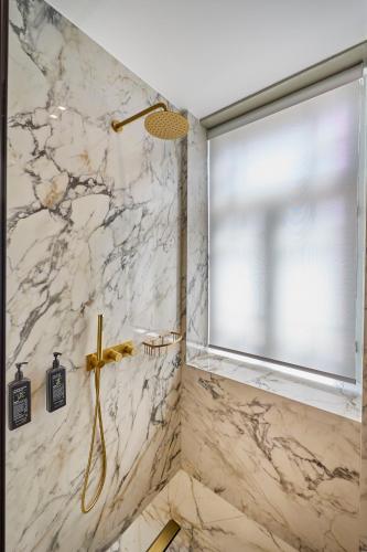 a bathroom with a shower with a window at Ermou 99 Intelligent Private Suites in Athens
