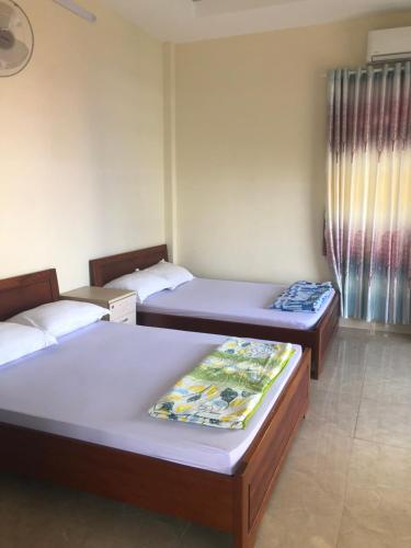 a room with three beds in a room at Quốc Ân Motel in Long Hai