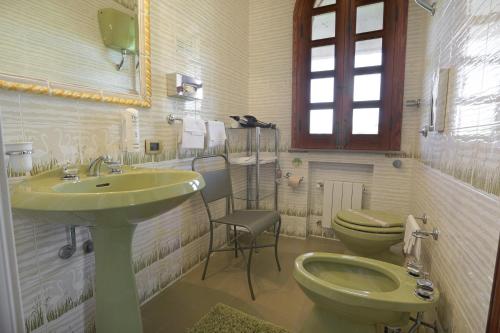 a bathroom with a green sink and a toilet at Villa Diana in Agrigento