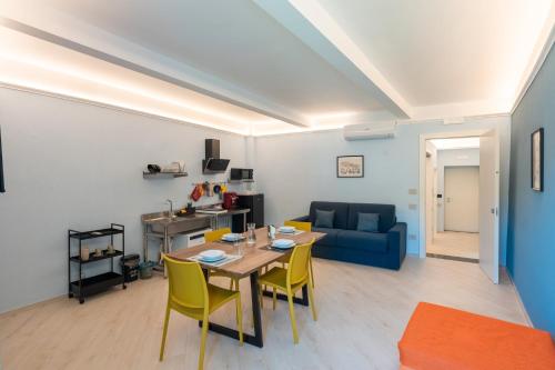 a living room with a table and yellow chairs at Palazzo Lucia in Ascea