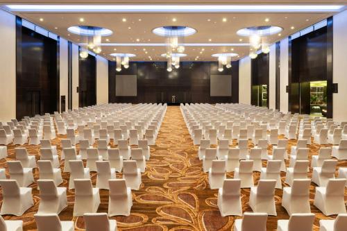 an empty banquet hall with white chairs and tables at Le Méridien Dubai Hotel & Conference Centre in Dubai