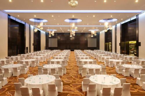 a large banquet hall with white tables and chairs at Le Méridien Dubai Hotel & Conference Centre in Dubai