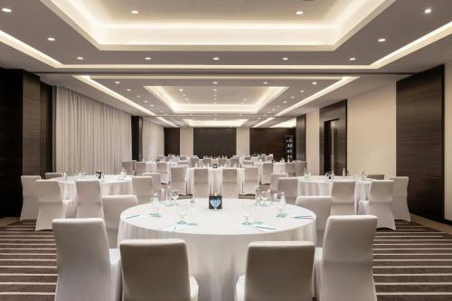 a banquet hall with white tables and white chairs at Le Méridien Dubai Hotel & Conference Centre in Dubai