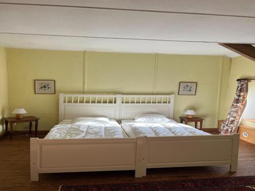 a large bed in a room with two tables at Charming Castle in Roumont in Roumont