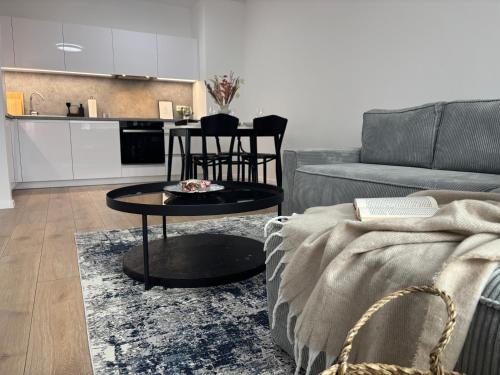 ein Wohnzimmer mit Sofa und Tisch in der Unterkunft Dvojizbový apartmán v centre in Poprad