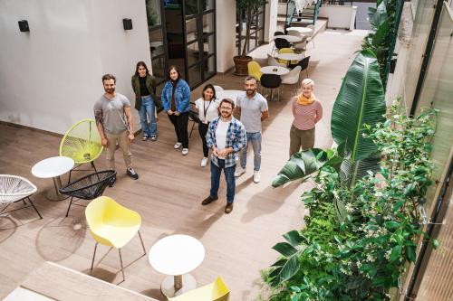a group of people walking in a room with plants at Dotcampus Roma City Center in Rome