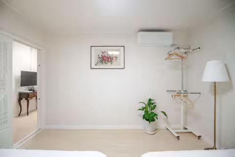 a white room with a potted plant and a lamp at 청기와하우스 in Busan