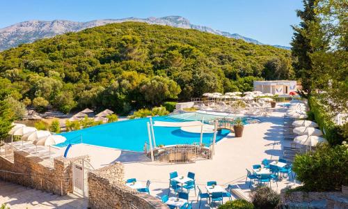 an outdoor swimming pool with a mountain in the background at Aminess Vival Port9 Residence in Korčula