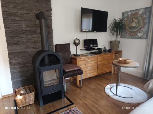 a living room with a wood stove and a desk at Ferienhaus Familie Zimmermann in Keutschach am See
