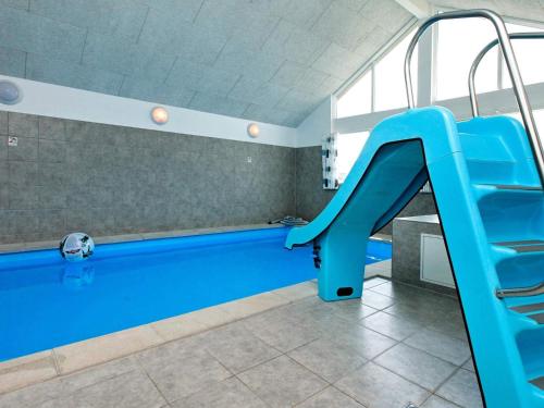 una piscina con scivolo blu in una stanza di Luxury Pool Villa by Sea - By Traum Ferienwohnungen a Bogense