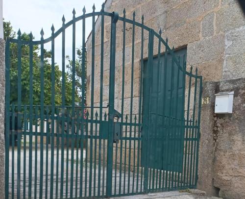 a green gate in front of a building at Casa da Mancha in Gouveia