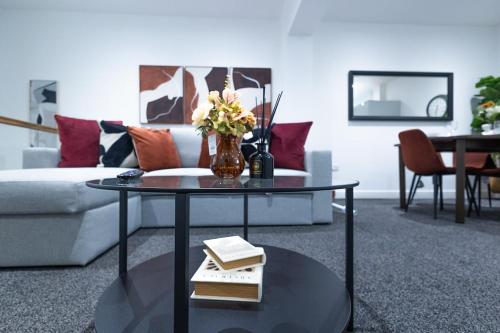 a living room with a couch and a table with books at Cozy Riverside Apartment 5mins to train station in Gravesend