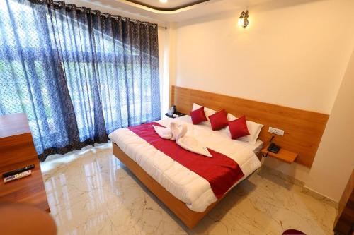a bedroom with a large bed with red pillows at The Brij Vista in Mathura