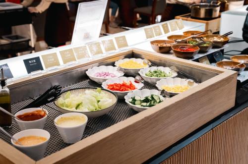 a buffet line with bowls of different types of food at Arsma Hotel in Hualien City