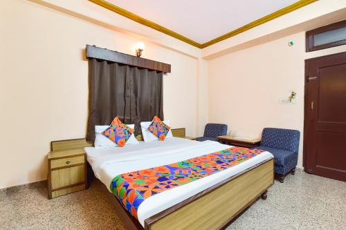 a bedroom with a bed and two blue chairs at FabHotel Jai Mangal Palace - Sindhi camp bus stand, Jaipur railway station,Sindhicamp metro station in Jaipur