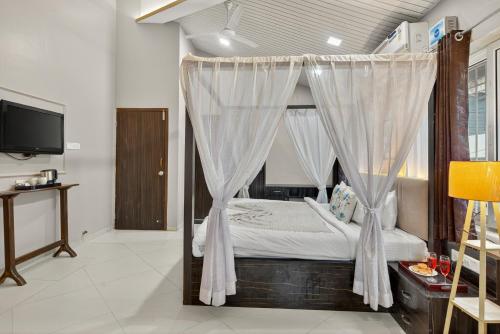 a bedroom with a canopy bed with white curtains at Alaya Stays Lavender Hills Stunning Hillside 3-BHK Villa With Private Pool, Gazebo and Views in Lonavala