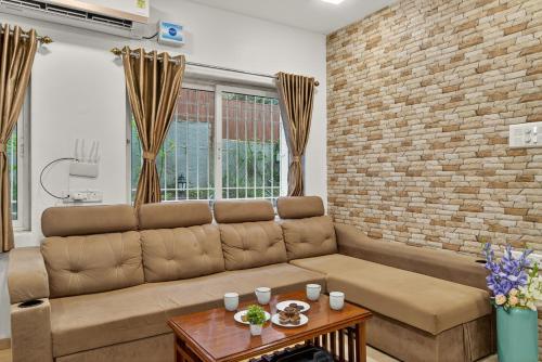 a living room with a couch and a brick wall at Alaya Stays Lavender Hills Stunning Hillside 3-BHK Villa With Private Pool, Gazebo and Views in Lonavala