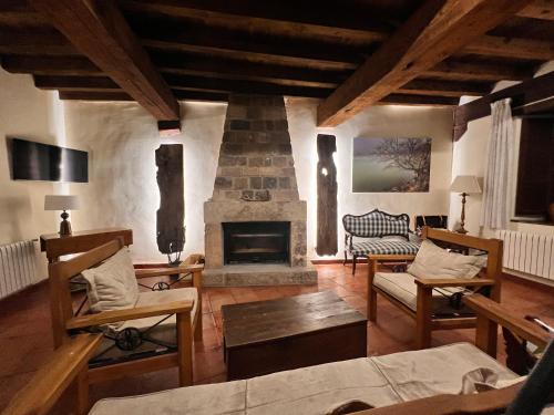 a living room with a fireplace and a couch at Posada Rural La Piñorra in Vinuesa