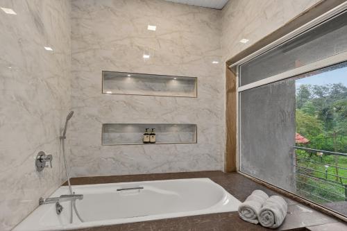 a large bathroom with a tub and a window at Alaya Stays Lavender Hills Stunning Hillside 3-BHK Villa With Private Pool, Gazebo and Views in Lonavala