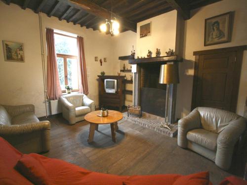 a living room with a fireplace and a table at Grand Family Farmhouse in Anthisnes in Anthisnes