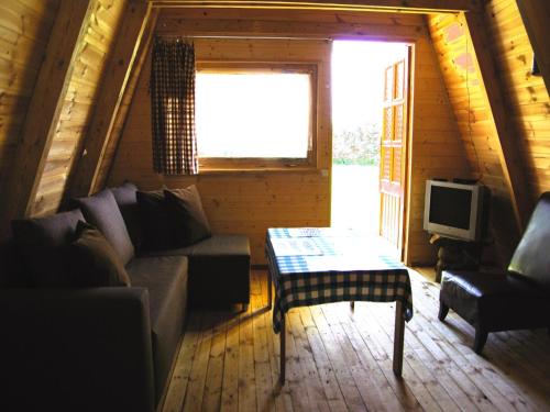 a living room with a couch and a tv at Summer house for 4 people, close to the sea in Łazy